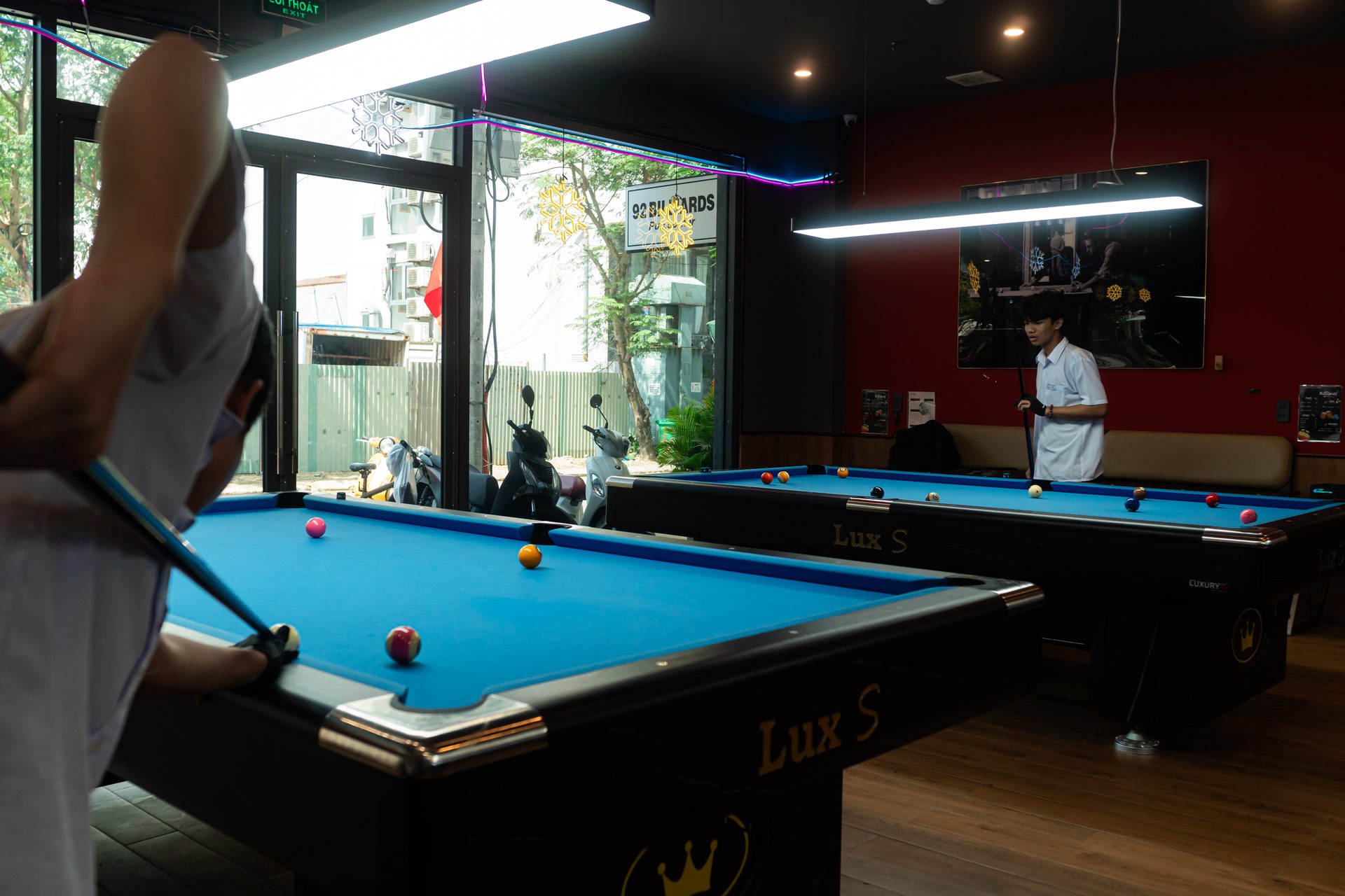 A player silhouetted against the window light at 92 Billiards Club